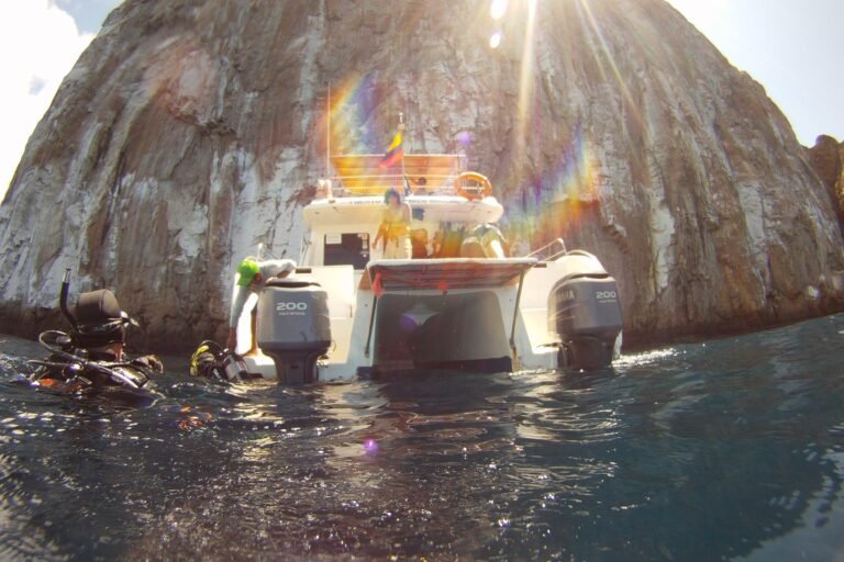 A dive boat moored at the foot of Kicker Rock