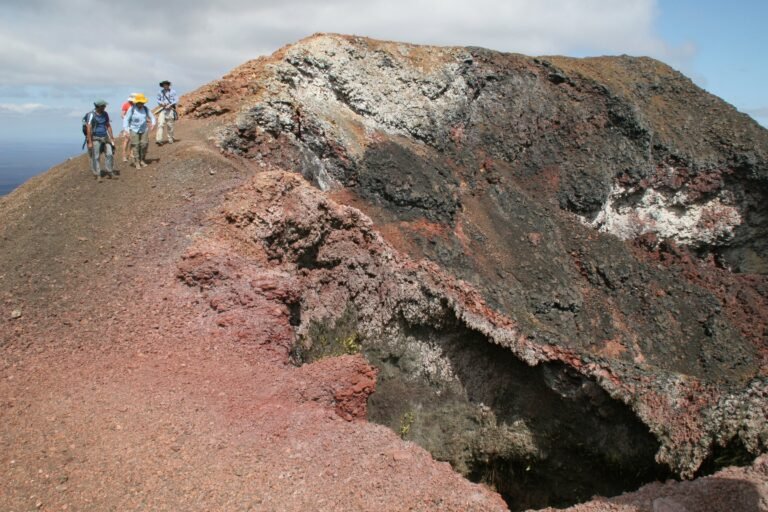 Walkers crossing the volcanic ground of Sierra Negra