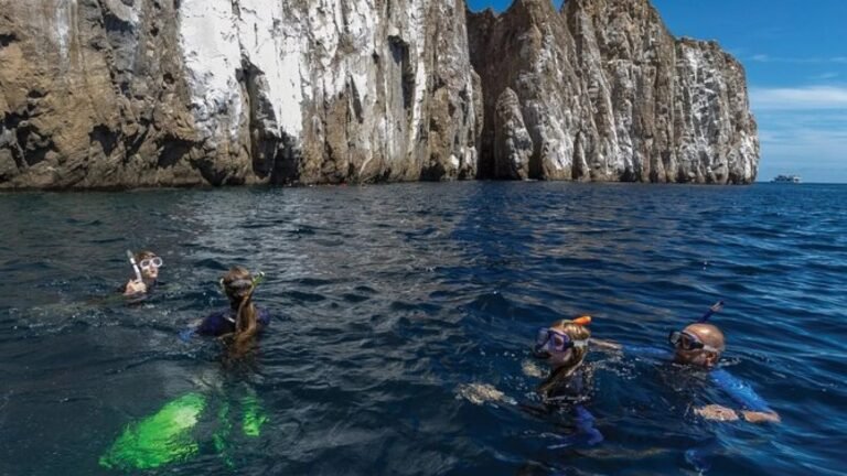 Snorkellers in the water in front of Kicker Rock